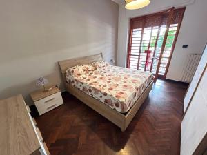 una camera da letto con un letto e un pavimento in legno di Regina34 a Torre a Mare