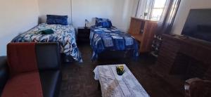 a bedroom with two beds and a couch and a table at Kuils River Apartment, near Cape Town Airport in Sarepta