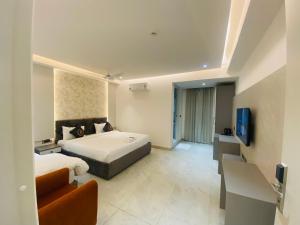 a bedroom with a bed and a couch and a television at Hotel Radhe Imperial in Hyderabad