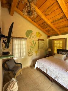 a bedroom with a bed and a flat screen tv at Cabañas Huerta la Mision, Zacatlán in Zacatlán