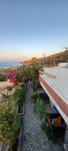 a view of a building with flowers and the ocean at Porto Kastri Studios in Kastrí