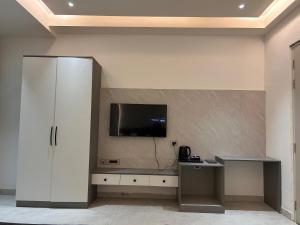 a living room with a tv on a wall at Hotel Radhe Imperial in Hyderabad