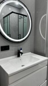 a bathroom with a white sink and a mirror at Улы дала in Shymkent +2 photos