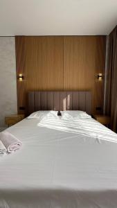 a large white bed with a wooden head board at Улы дала in Shymkent