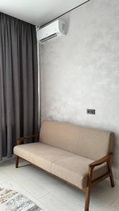 a couch sitting in a living room with a window at Улы дала in Shymkent
