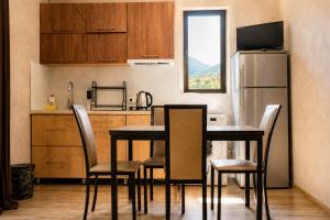 a kitchen with a table and chairs and a refrigerator at Cottage Shina in Kazbegi