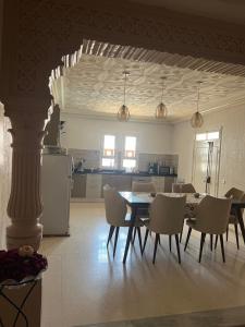 a kitchen and dining room with a table and chairs at La villa jasmin in Al Maqārisah