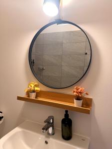 a bathroom sink with a round mirror on a wall at Apartments Chloe - Top 4 in Hollabrunn +7 photos