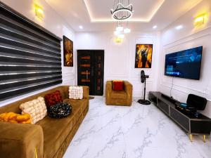 a living room with a couch and a flat screen tv at Layiz Court in Lagos
