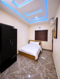 a bedroom with a bed and a blue ceiling at Layiz Court in Lagos
