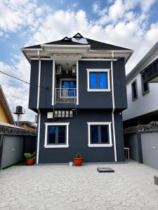 a blue house with a balcony on top of it at Layiz Court in Lagos
