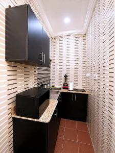 a kitchen with black cabinets and a counter top at Layiz Court in Lagos