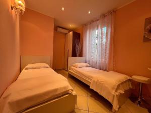 two beds in a room with a window at Le Palme Di Como in Como