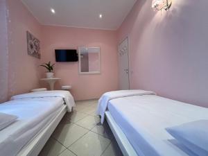 two beds in a room with pink walls at Le Palme Di Como in Como