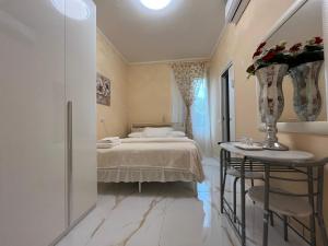 a bedroom with a bed and a table with flowers on it at Le Palme Di Como in Como