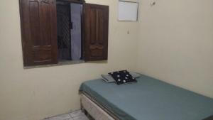 a small room with a bed and a window at Casa 2 quartos em frente a praia na cidade mística de colares a 96 quilômetros de Belém do Pará in Colares