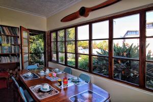a dining room with a table and some windows at Zoete Inval Travelers Lodge-Backpacker Loft in Hermanus