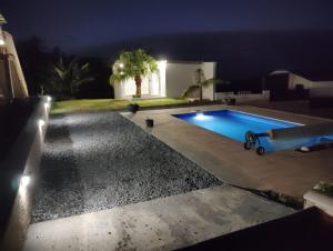a swimming pool in a backyard at night at Chez Marie Line in Saint-Joseph