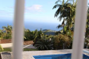 a view of the ocean from a house through a window at Chez Marie Line in Saint-Joseph +1 photo
