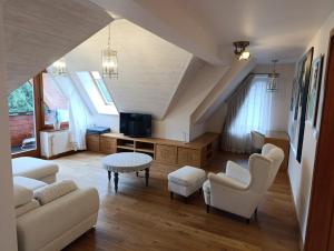 a living room with a couch and chairs and a tv at Secret Residence with Sauna & Private Pool in Kościelisko +8 photos