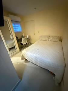 a bedroom with a bed and a desk and a window at Fantástico in Juan López