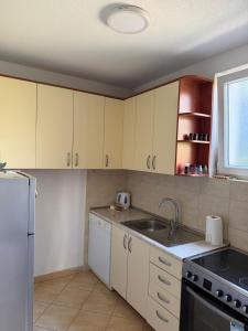 a kitchen with white cabinets and a sink at Emama Residence Mostar in Mostar