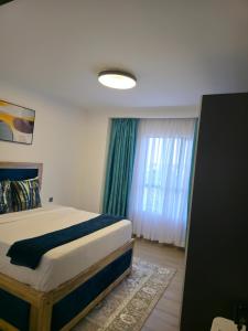 a bedroom with a bed and a large window at Haven 2 lustic in Nairobi