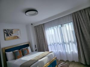 a bedroom with a bed and a large window at Haven 2 lustic in Nairobi