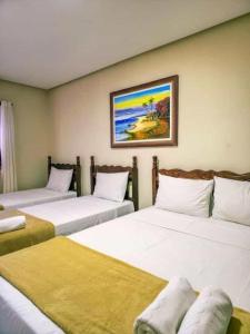 a room with four beds with a painting on the wall at Vila Sancar Pousada in Lençóis