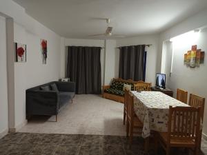 a living room with a table and a couch at Golden Beach 1 for family in Ras Sedr