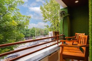 two chairs on a balcony with a view of a street at Hotel Royal Comforts in Pune