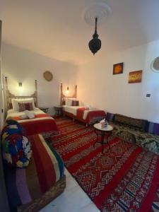 a bedroom with two beds and a rug at Rif House MEDIOUNA in Tangier