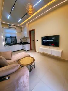 a living room with a couch and a table and a tv at Cozynest nungwi in Nungwi