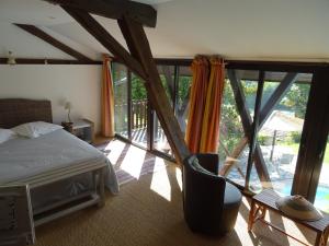 a bedroom with a bed and a view of a balcony at GITE Au Moulié in Blousson-Sérian +24 photos
