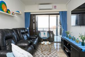 a living room with a leather couch and a chair at Luxury Ocean View Escape with Private Rooftop -Sancta Maria in Kingsborough