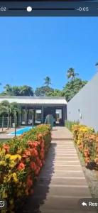 a picture of a pathway with flowers in front of a building at Casa 108 in Guaibim