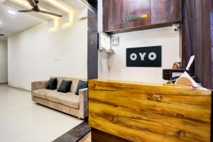 a living room with a couch and a sign on the wall at SPOT ON Hotel Shree Ji in Indore