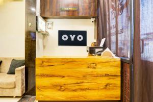a wooden counter with an ovo sign on a wall at SPOT ON Hotel Shree Ji in Indore
