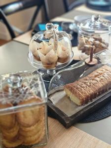 a table with various pastries and cakes in glass containers at Chambres d'hôtes "Le Petit Cardinal" - proche PuyduFou in Mauléon