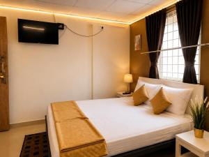 a bedroom with a bed with a television on the wall at Leo Stays in Bangalore +18 photos