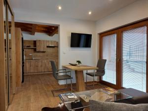 a living room with a table and chairs and a tv at Village Premium Apartment by Český Krumlov Adults Only in Střížov