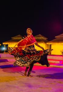 a person in a dress dancing on the ice at Jaisalmer Sand Dunes Resort in Jaisalmer