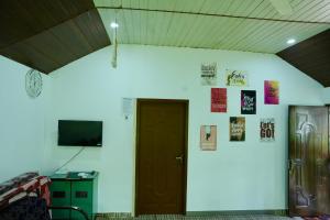 a room with a door and posters on the wall at CatsClaw Inn in Talayolaparambu