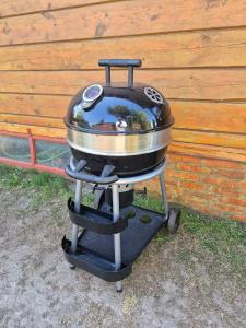 a grill sitting on a stand next to a wall at Leonówka in Nowogród +8 photos