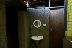 a bathroom with a sink and a mirror on the wall at CatsClaw Inn in Talayolaparambu