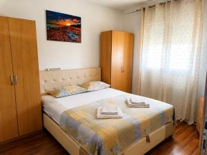 a bedroom with a bed with two towels on it at Bgd apartman in Kavač