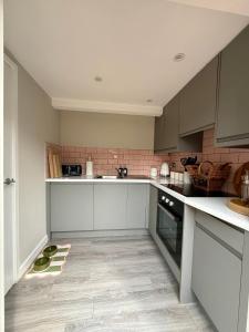 a kitchen with white cabinets and a counter at The Willow Luxury Countryside Retreat in Stone +9 photos