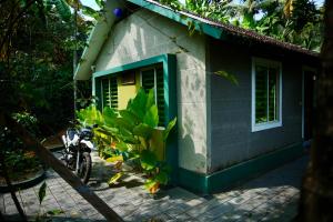 a motorcycle parked outside of a house with a window at CatsClaw Inn in Talayolaparambu +12 photos