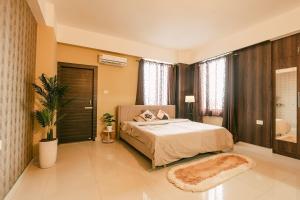 a bedroom with a large bed and a bathroom at CueCasa in Guwahati