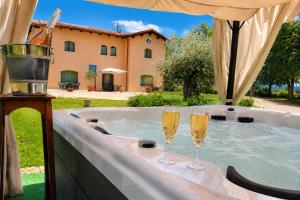 two glasses of champagne are sitting in a hot tub at Il Castellaccio in Spello